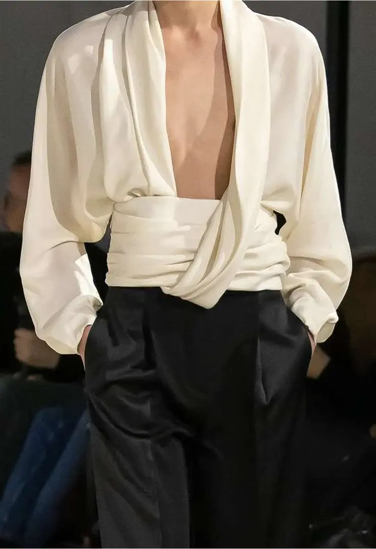 homme portant une chemise blanche ouverte et un pantalon noir