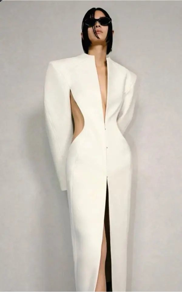femme portant une longue robe blanche, épaulettes et cut-out au niveau des hanches