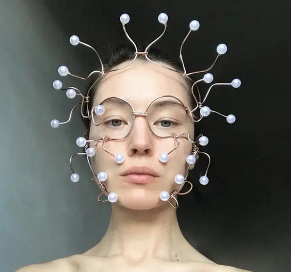 femme avec bijou de tête composée de fil doré et de perles blanches